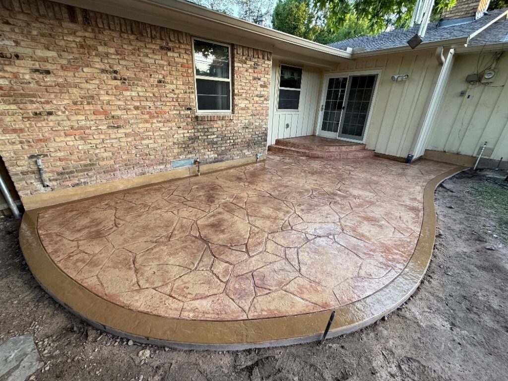 Stamped concrete patio with flagstone pattern installed by Fence Guy