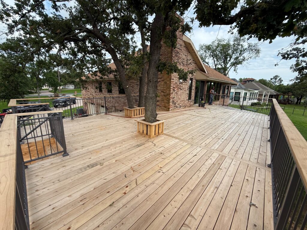 Large custom wood deck with metal railing built by Fence Guy in DFW and North Texas